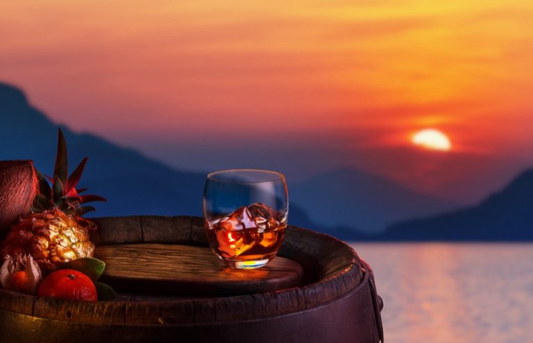 Glass,Of,Iced,Dark,Rum,And,Tropical,Fruits,Over,Oak